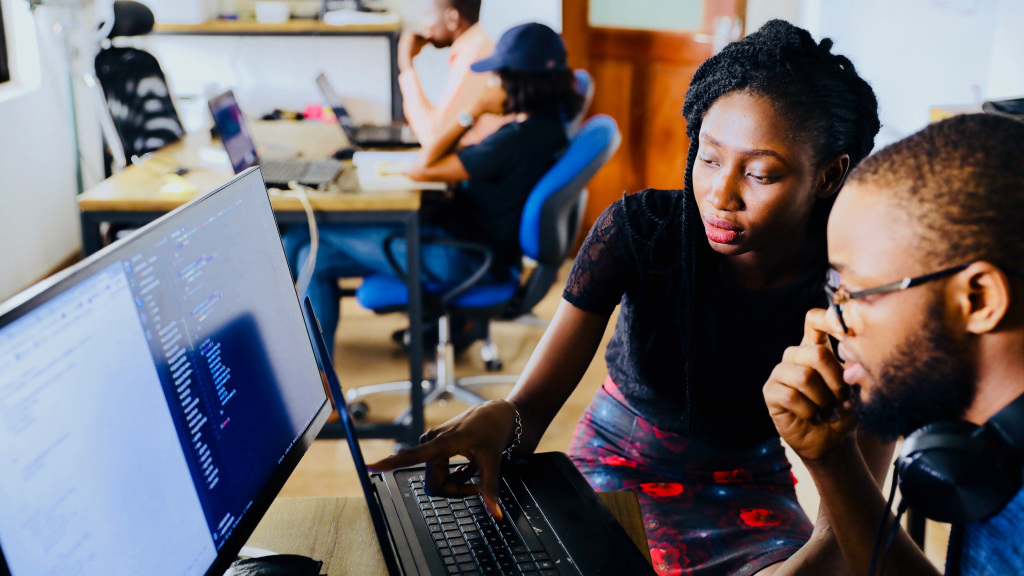 Two people sitting at a computer. 